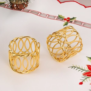 Set of two gold woven X-shaped metal napkin rings on a festive holiday tablecloth