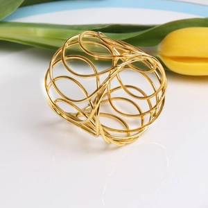 Macro shot of gold hollow woven napkin ring featuring elegant geometric metal mesh design