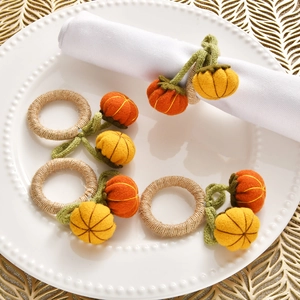 Detail of handmade fabric pumpkin napkin rings with woven rope loops and felt leaves