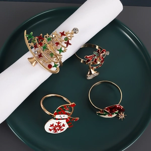 Lot de quatre ronds de serviette de Noël avec émail et strass sur une assiette en céramique