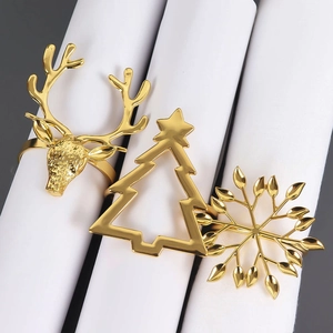 Trois ronds de serviette de Noël dorés avec motifs de renne, sapin et flocon de neige