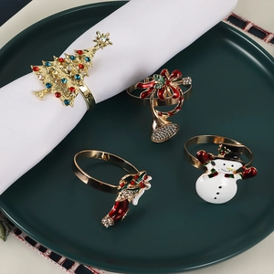 Close-up of golden Christmas tree and snowman napkin rings with enamel and rhinestones