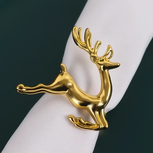 Polished gold reindeer napkin ring on white fabric for elegant Christmas table settings