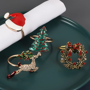 Christmas napkin ring set with reindeer and tree designs on green plate background