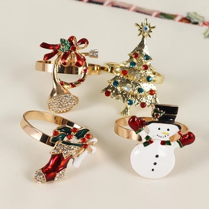 Detailed view of four Christmas napkin rings with reindeer, tree, and snowman designs
