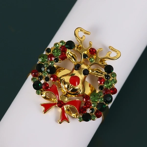 Golden Christmas napkin ring with rhinestone reindeer head and festive red enamel bow