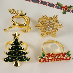Detail of gold Christmas napkin rings featuring reindeer, snowflake, tree and letters