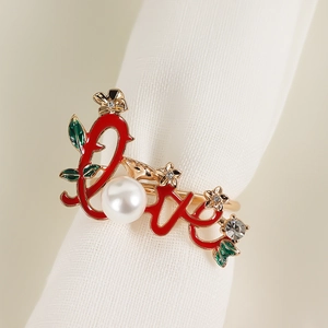 Detail eines goldenen LOVE Serviettenrings mit roter Emaille, Perle und funkelnden Kristallen