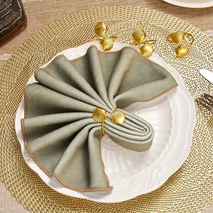 Elegant gold shell napkin ring on a green velvet napkin atop a white porcelain plate