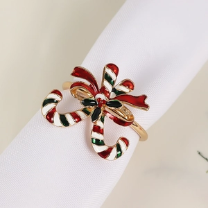 Close-up of golden Christmas napkin ring with red and green enamel candy canes