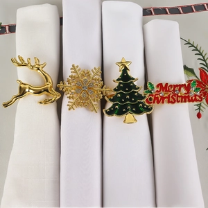 Close-up of assorted festive gold napkin rings with reindeer, snowflake, and tree designs