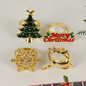 Close-up of set of 4 gold Christmas napkin rings with reindeer and snowflake details