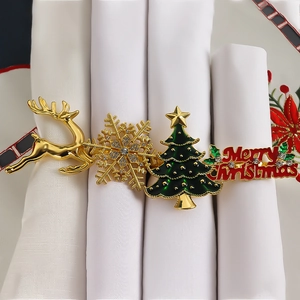 Detail of Christmas napkin rings featuring golden deer, rhinestone snowflake and tree