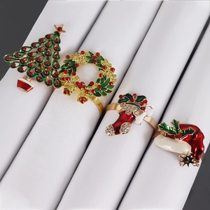 Close-up of four Christmas napkin rings including tree, wreath, and hat with gold plating