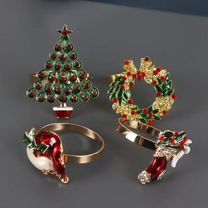 Macro detail of jeweled Christmas napkin rings with red and green enamel on gold finish