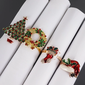 Detailed view of Christmas napkin rings set with festive enamel and rhinestone motifs