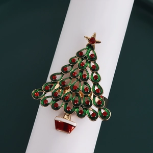 Macro detail of Christmas tree napkin ring with green enamel and red crystal studs