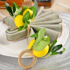 Handmade lemon napkin ring with yellow citrus and green leaves on woven jute rope