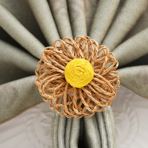 Detailed close-up of handmade daisy napkin ring with woven petals on a linen napkin