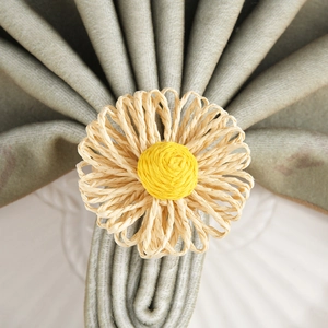 Detailed top view of a handmade bohemian daisy napkin ring on a folded green cloth