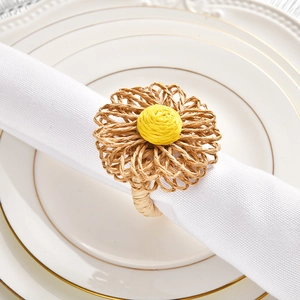 Detail of handmade raffia flower napkin ring showing natural woven texture and yellow center