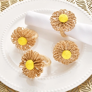 Handmade bohemian straw flower napkin rings set of 4 on a white ceramic plate