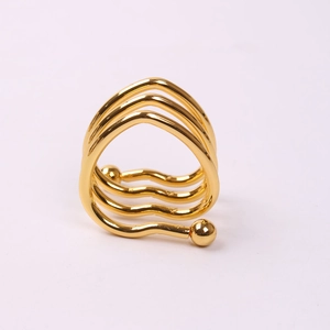 Macro shot of multi-layer wavy gold napkin ring with smooth spherical metal accents