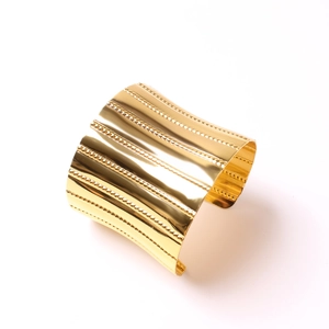 Minimalist wide gold-plated metal napkin ring with elegant vertical textured stripes
