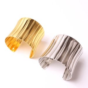 Modern gold and silver napkin rings with vertical stripes and beaded texture detail
