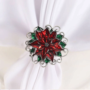 Detail eines roten Poinsettia-Serviettenrings mit grünen Blättern und Silberdekor