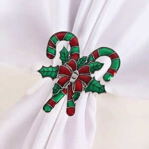 Kreativer Weihnachts-Serviettenring mit Zuckerstange und roter Schleife auf weißem Tuch