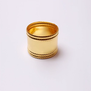 Detailed view of glossy gold-plated napkin ring with elegant double-beaded textured edges