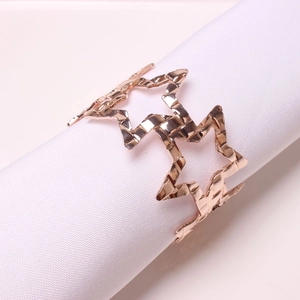 Detail of rose gold star napkin ring with hollow stars and hammered metal finish