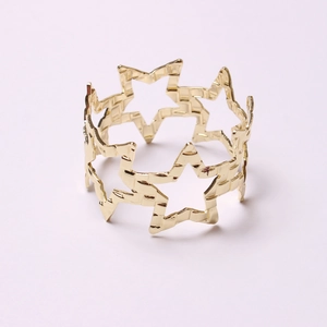 Detailed macro view of the gold hollow star-shaped napkin ring with hammered metal texture