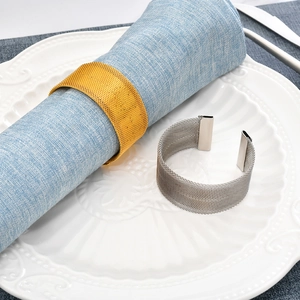 Elegant gold and silver metal woven napkin rings displayed on a white plate