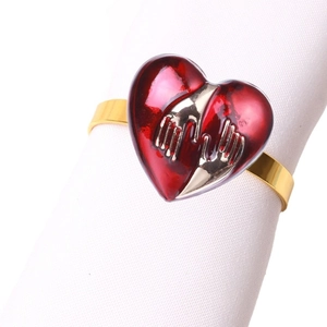 Golden napkin ring with red heart featuring hug motif for Christmas dining decor