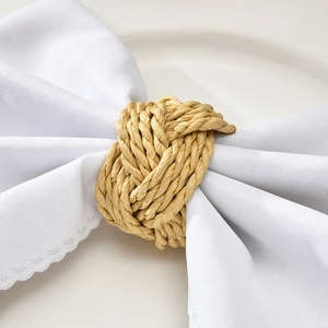 Handcrafted natural woven straw napkin ring knot on a white cotton linen napkin