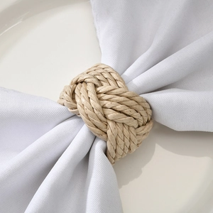 Handcrafted natural cattail woven napkin ring on white fabric for rustic table setting