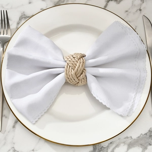 Close-up of handmade natural fiber woven napkin ring on a luxury ceramic plate