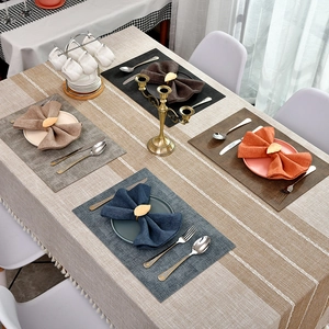 Modern striped linen tablecloth with decorative tassels and four colorful placemats