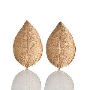 Detailed close-up of golden leaf napkin rings showing intricate vein patterns and textures