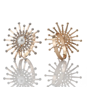 Sparkling firework napkin rings with pearls and crystals on polished gold metal base