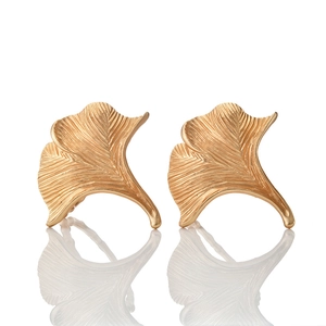 Macro shot of gold ginkgo leaf napkin ring with detailed texture on white background