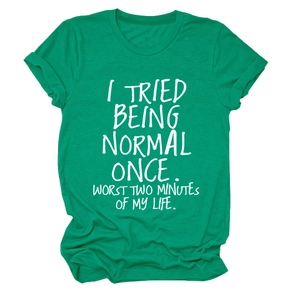 Détail du t-shirt en coton vert émeraude avec texte imprimé blanc sur fond blanc