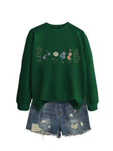 Detail of dark green floral sweatshirt featuring colorful prints and ribbed cuffs