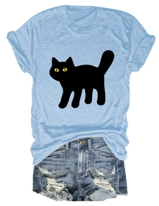 Flat lay of light blue T-shirt with black cat print and distressed denim shorts
