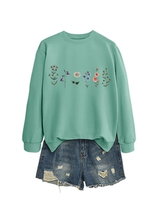 Detail of light green sweatshirt with floral print and frayed denim shorts set