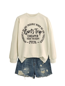 Flat lay of beige sweatshirt with 'Girl's Trip' slogan paired with denim shorts