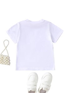 Flat lay of a white kids' cotton t-shirt paired with sneakers and a pearl handbag