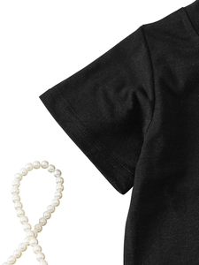 Detail view of black cotton T-shirt sleeve showing double-needle stitching and fabric texture